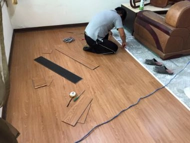 客廳地板施工中，鋪設超耐磨卡扣木紋地板。